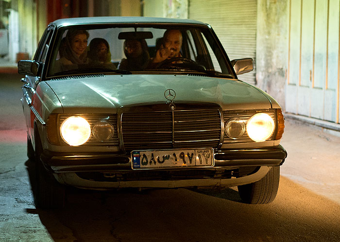 Eine freundliche iranische Familie in ihrem alten Mercedes